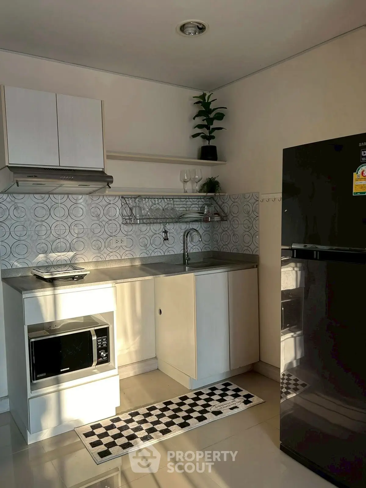 Modern kitchen with sleek appliances and stylish backsplash in a cozy apartment.