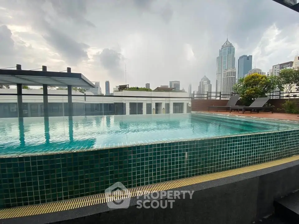 Luxurious rooftop pool with stunning city skyline views, perfect for relaxation and leisure in urban living.