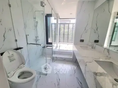 Luxurious marble bathroom with modern fixtures and large glass shower enclosure