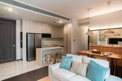 Modern open-plan living room and kitchen with stylish decor and dining area.