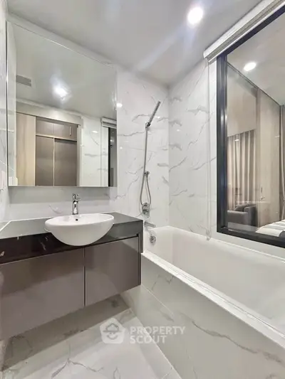 Modern bathroom with sleek design, featuring a bathtub and large mirror, perfect for relaxation and style.