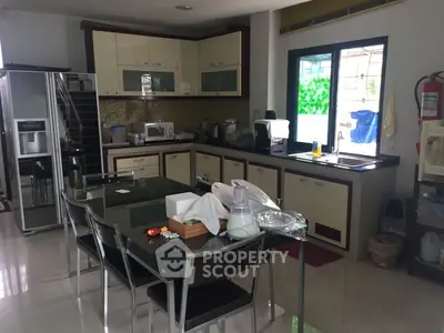 Spacious modern kitchen with sleek cabinetry and dining area, perfect for family gatherings.