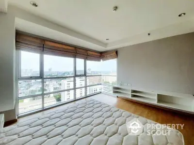 Spacious corner unit with expansive city views, featuring large windows, ample natural light, and a modern design with sleek built-in shelving.