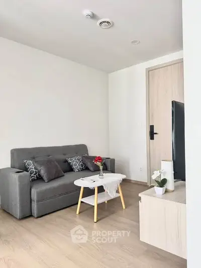 Modern living room with sleek gray sofa and stylish decor in a contemporary apartment.