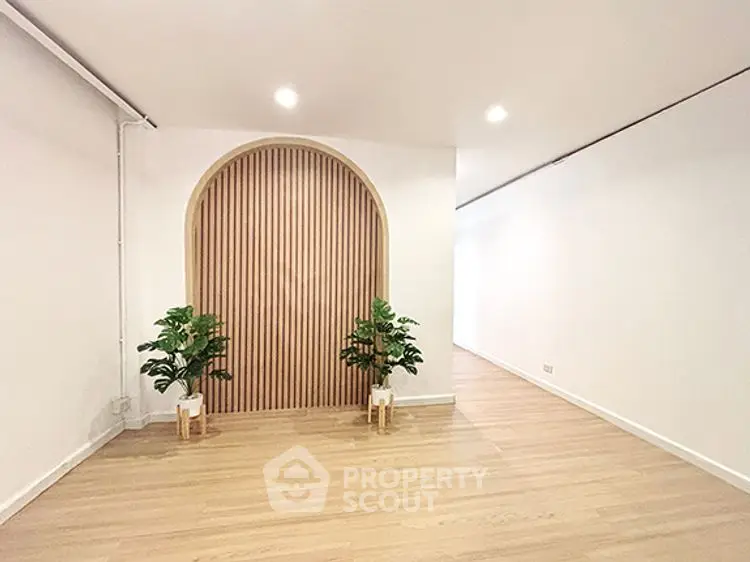 Spacious modern interior with wooden flooring and stylish arch design, perfect for contemporary living.