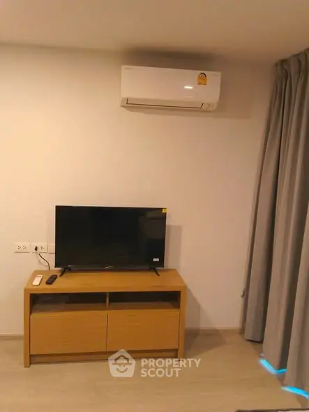 Modern living room with TV and air conditioning unit, ideal for comfortable living.