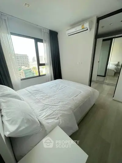 Modern bedroom with large window and air conditioning in a high-rise apartment.