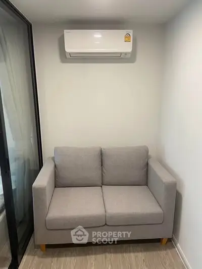 Cozy living room with modern air conditioning and stylish gray sofa, perfect for relaxation.