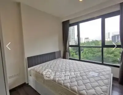 Spacious bedroom with large windows offering a stunning city view