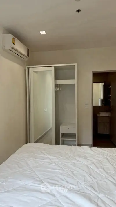 Cozy bedroom with mirrored closet and air conditioning unit