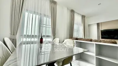 Modern living room with elegant marble dining table and cozy seating area.