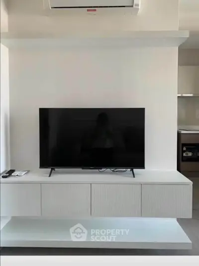 Modern living room with sleek TV setup and air conditioning unit
