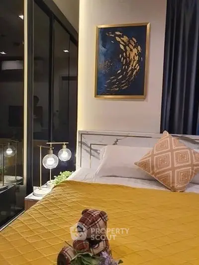 Cozy bedroom with modern decor and large window view, featuring stylish lighting and plush bedding.