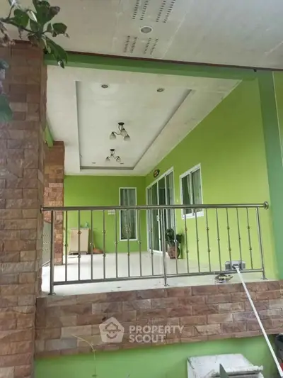 Charming green balcony with modern railing and stone accents, perfect for relaxation.