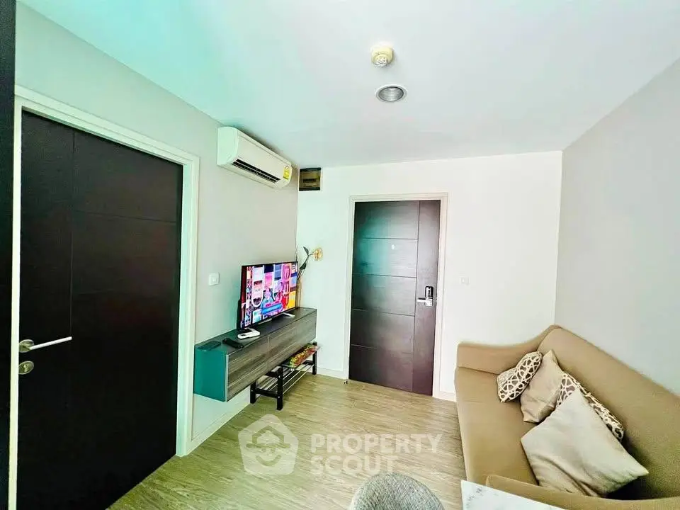 Modern living room with cozy sofa and wall-mounted TV in stylish apartment.