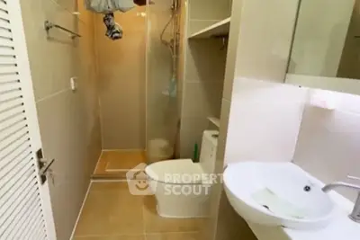 Compact bathroom with modern fixtures and shower in cozy apartment.