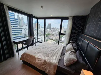 Luxurious bedroom with panoramic city views and modern furnishings.