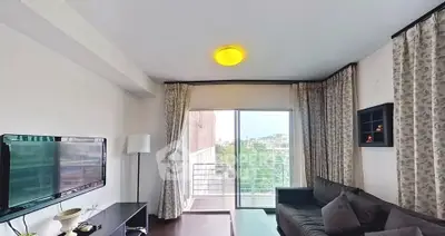Modern living room with balcony view, stylish decor, and natural light.