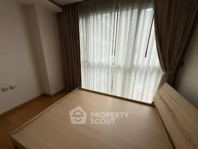 Spacious bedroom with large window and elegant curtains in modern apartment