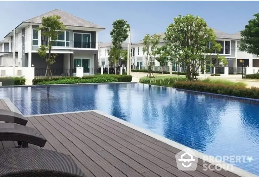 Luxurious residential community with modern houses and a pristine swimming pool.