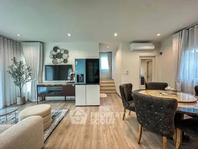 Elegant open-plan living and dining area with modern decor and natural light.