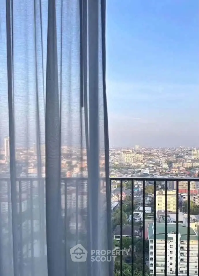 Stunning cityscape view from a high-rise balcony with sheer curtains, perfect for urban living.