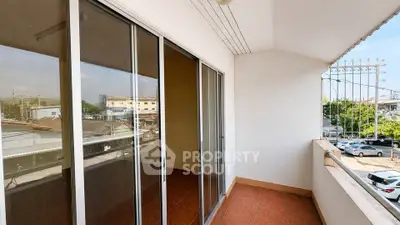 Spacious balcony with sliding glass doors and city view, perfect for relaxation and outdoor enjoyment.