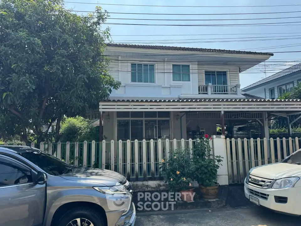 Charming two-story house with a fenced garden and driveway, perfect for family living.