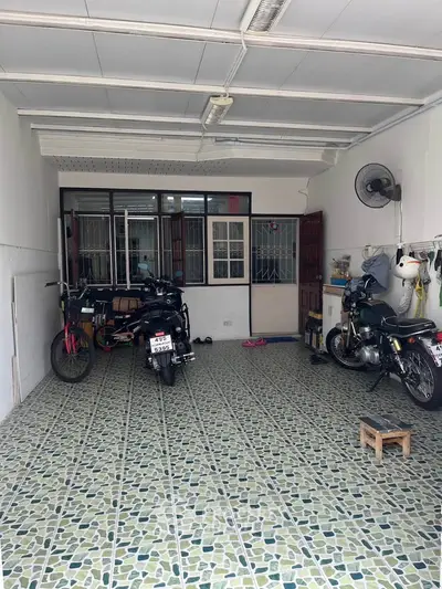 Spacious tiled garage with motorcycles and storage space, ideal for vehicle enthusiasts.