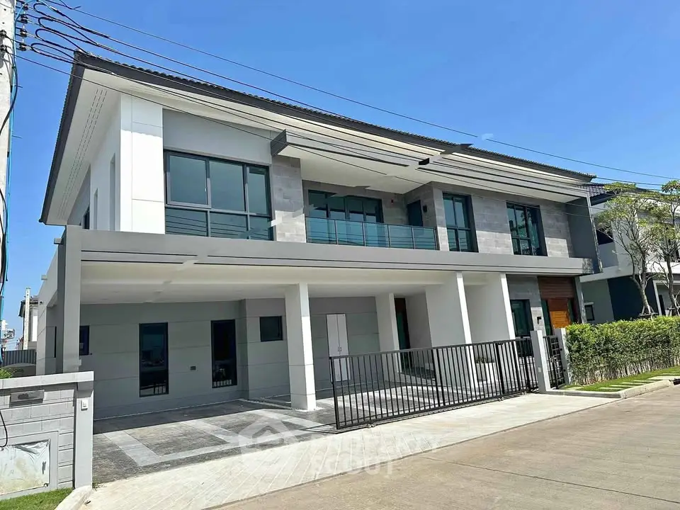 Modern two-story house with spacious driveway and sleek design in a suburban neighborhood.