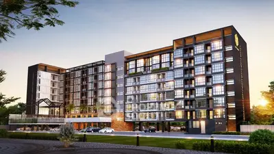 Modern apartment building with sleek design and large windows at sunset.