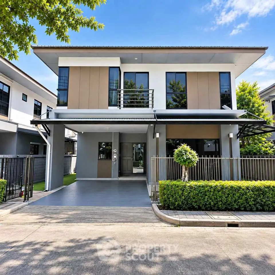 Modern two-story house with sleek design and manicured landscaping in a suburban neighborhood.