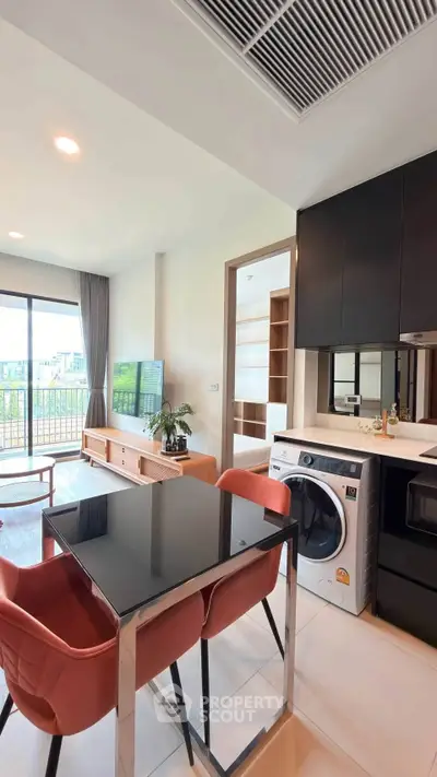 Modern open-plan living room with sleek kitchen and balcony view