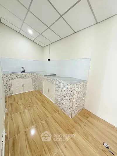 Modern kitchen with sleek countertops and tiled flooring, perfect for culinary enthusiasts.