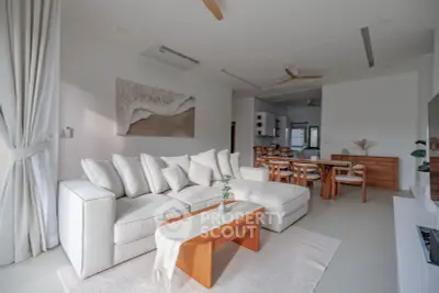 Spacious modern living room with elegant white sofa and wooden accents, perfect for relaxation and entertaining.