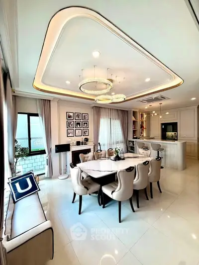Luxurious dining area with elegant chandelier and modern decor in a spacious open-plan layout.