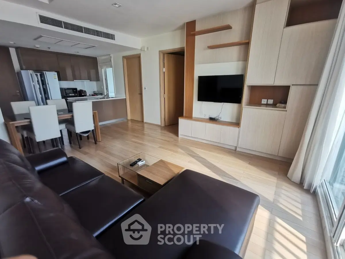 Spacious modern living room with open kitchen and sleek furniture in a bright apartment.