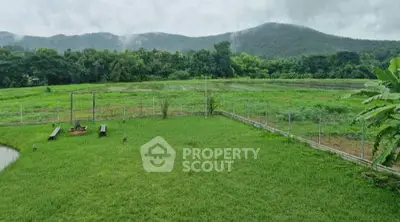 Expansive green field with mountain views, perfect for serene living or development.