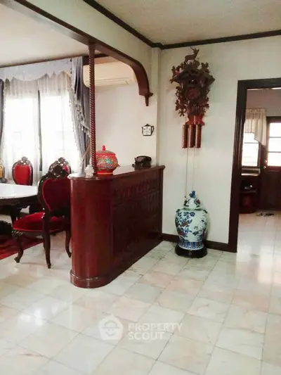 Elegant living room with classic wooden furniture and decorative vase, perfect for sophisticated gatherings.