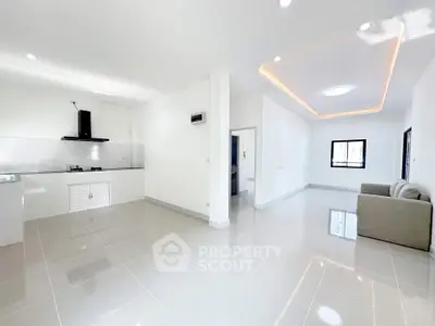 Spacious modern living room with open kitchen layout and sleek design.