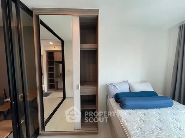 Modern bedroom with sleek wardrobe and comfortable bed in stylish apartment.