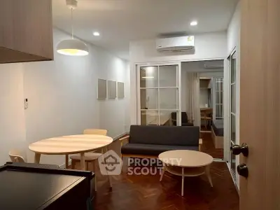 Modern living room with sleek furniture and wooden flooring in a cozy apartment.