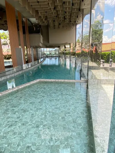 Luxurious indoor swimming pool with modern design and floor-to-ceiling windows.