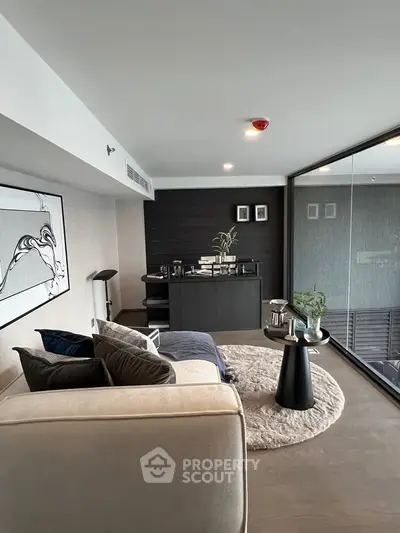 Modern living room with stylish decor and large glass windows offering natural light.