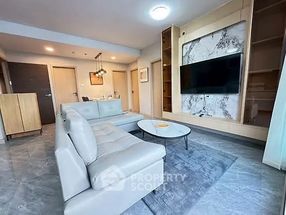 Modern living room with sleek furniture and wall-mounted TV in stylish apartment.