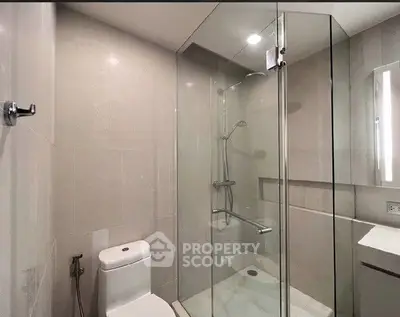 Modern bathroom with glass shower enclosure and sleek fixtures.