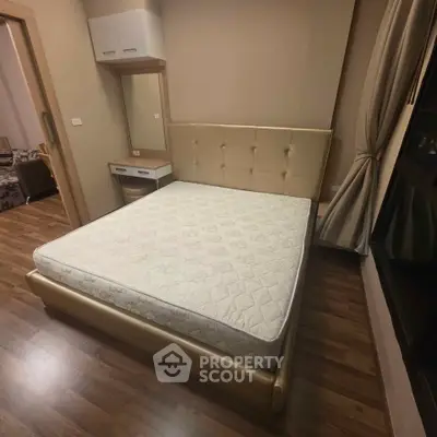 Spacious bedroom with elegant wooden flooring and modern furnishings in a cozy apartment.