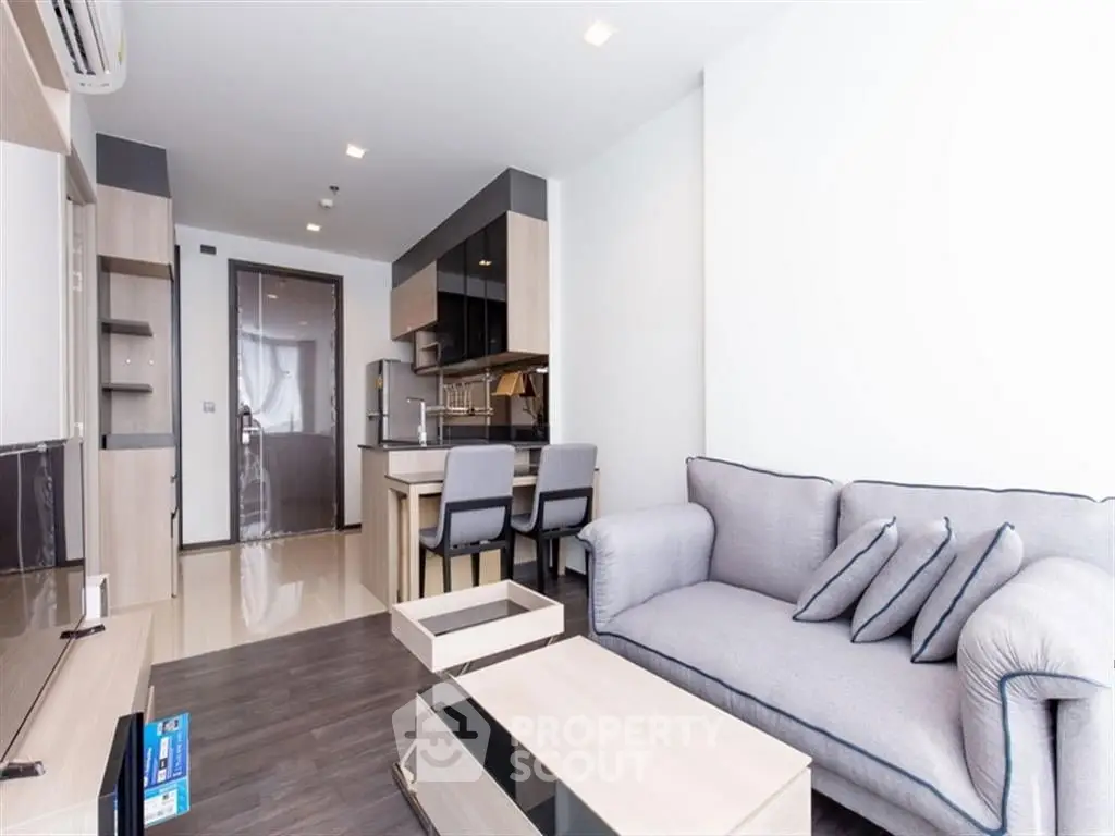 Modern living room with open kitchen and stylish furniture in a cozy apartment.