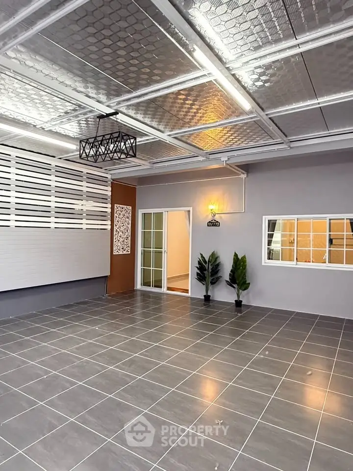 Spacious modern garage with sleek tiled flooring and stylish lighting, perfect for secure parking or versatile use.