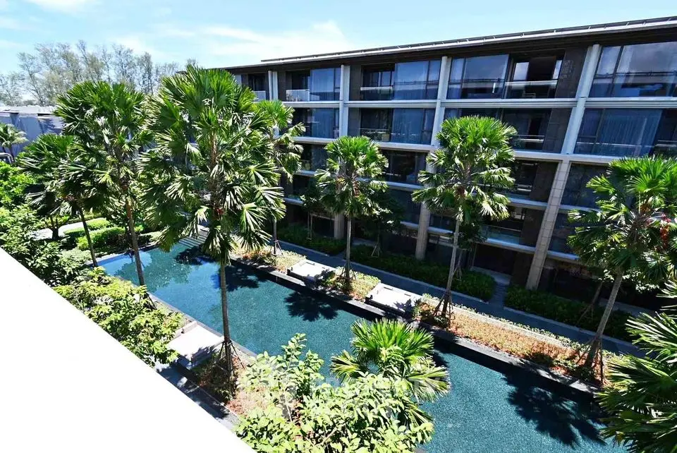 Luxurious resort-style building with lush gardens and serene pool view